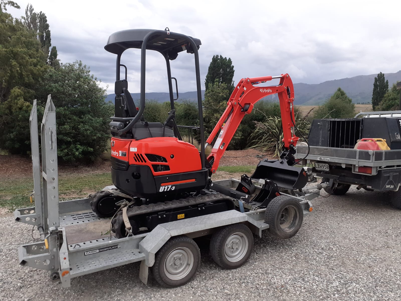 Hire South Kubota U17-3 mini digger secured on a tandem plant trailer ready for transport to site, Central Otago